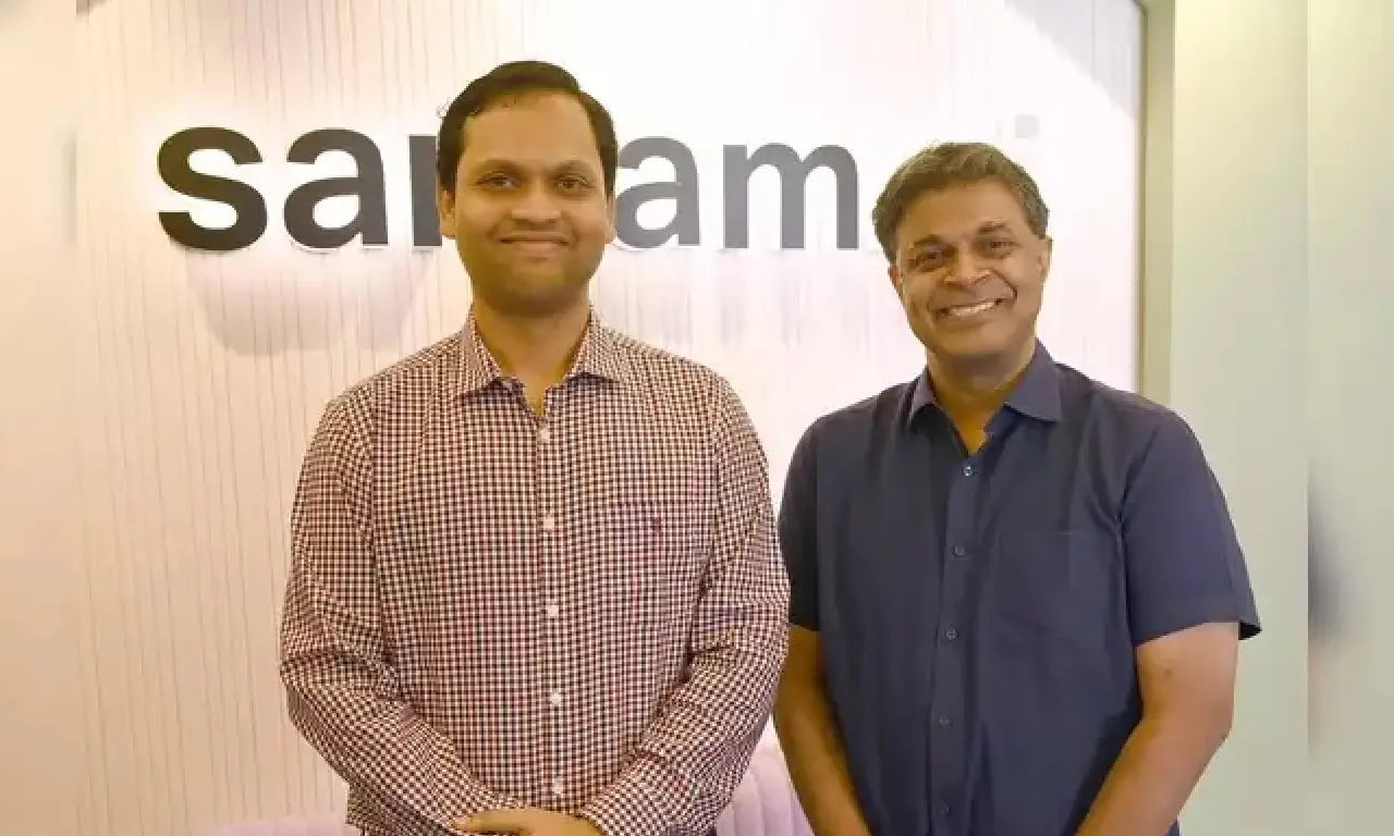 Sarvam AI co-founders Vivek Raghavan and Pratyush Kumar standing together in front of the Sarvam office signage.
